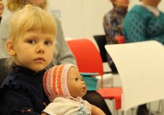 Een peuter en haar pop