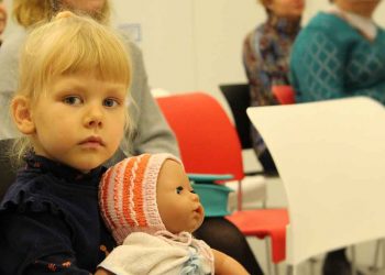 Een peuter en haar pop