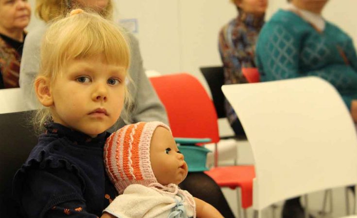 Een peuter en haar pop